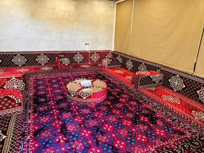 a room with a red and blue carpet and a table at شقق الياسمين in Jerash