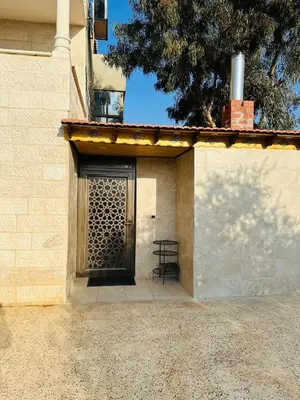 a door to a building with a chair next to it at شقق الياسمين in Jerash
