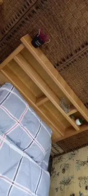 a bed with blue pillows and a wooden shelf at Jasmine's House in Jerash