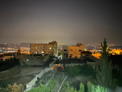 a view of a city at night at Jasmine's House in Jerash