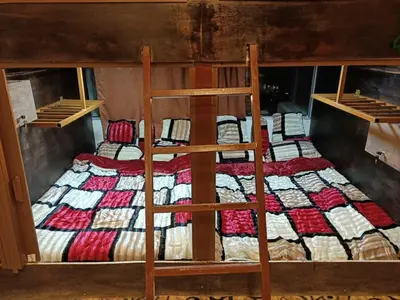 a bedroom with two bunk beds with a quilt at PETRA Cabin Dorms Hostel in Wadi Musa