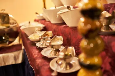a long table with plates and silver dishes on it at PETRA Cabin Dorms Hostel in Wadi Musa