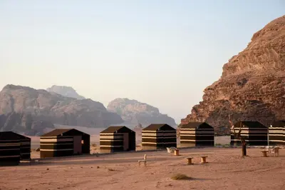a group of huts in the desert near mountains at Wadi rum galaxy camp in Wadi Rum