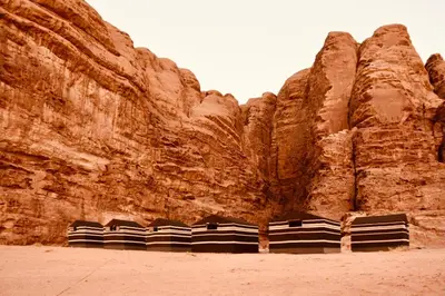 a row of chairs in front of a rock wall at Wadi rum galaxy camp in Wadi Rum