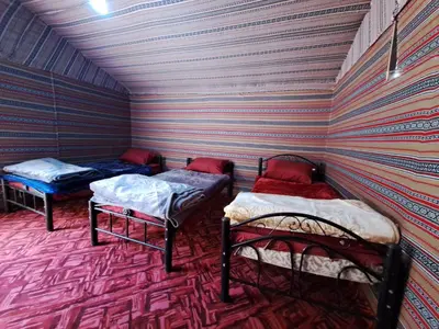 two beds in a room with a striped wall at Wadi rum galaxy camp in Wadi Rum
