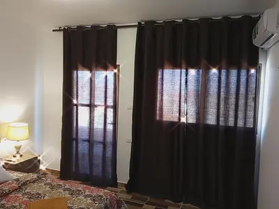 a bedroom with black curtains and a bed and a window at Petra Planet in Wadi Musa