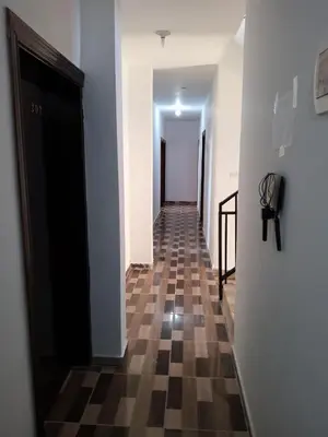 a hallway with a checkered floor and a black door at Petra Planet in Wadi Musa