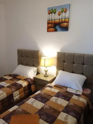 a bedroom with two beds and a painting on the wall at Petra Planet in Wadi Musa