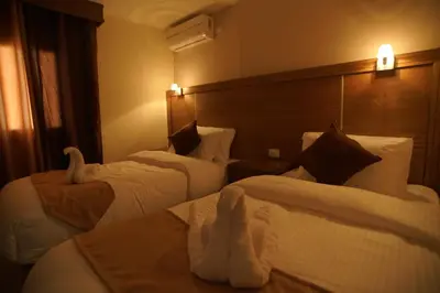 a hotel room with two beds with towels on them at Petra Aretas Hotel in Wadi Musa