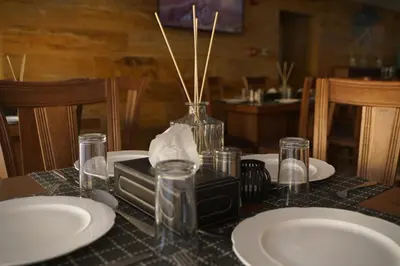 a table with plates and a vase on top of it at Petra Aretas Hotel in Wadi Musa