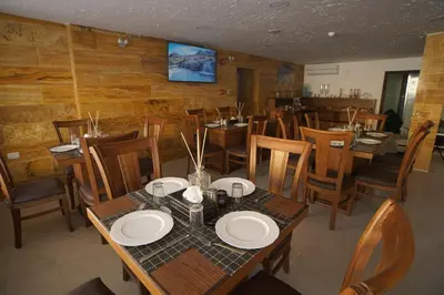 a dining room with wooden tables and chairs at Petra Aretas Hotel in Wadi Musa