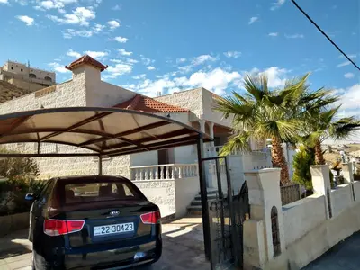 a car parked under a shelter in front of a house at Horizon in Wadi Musa