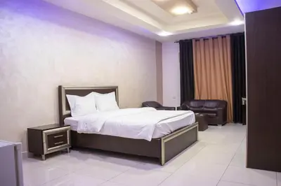 a hotel room with a bed and a chair at Sara Crown Hotel in Irbid