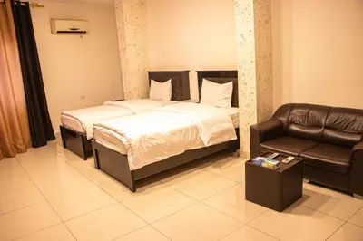 a bedroom with a bed and a leather chair at Sara Crown Hotel in Irbid