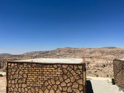 a brick wall with the desert in the background at Al-Nawatef ECO camp- Dana Nature Reserve in Dana