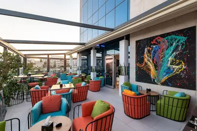 a restaurant with colorful chairs and tables on a building at Coral Tower Hotel by Hansa in Amman