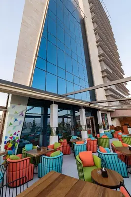 a restaurant with colorful chairs and tables in front of a building at Coral Tower Hotel by Hansa in Amman