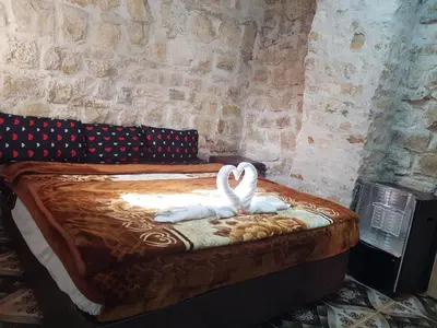 two swans sitting on a bed in a room at Dana moon Hotel in Dana