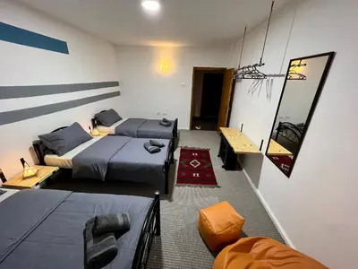 a room with two beds and a table and a mirror at Euphoria guest house in Wadi Musa