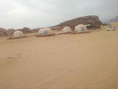 three domes in the middle of a desert at Wadi Rum Nova camp in Wadi Rum