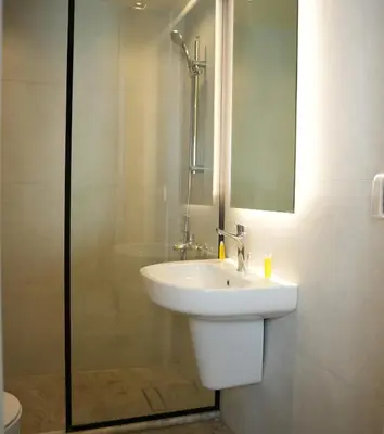 a bathroom with a white sink and a shower at Abu Alsoud Hotel in Amman
