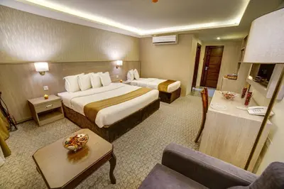 a hotel room with two beds and a couch at Nairoukh Hotel Aqaba in Aqaba