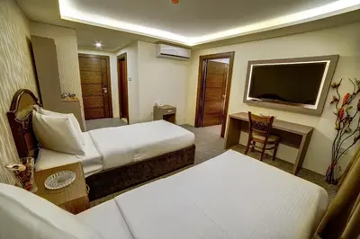 a hotel room with two beds and a television at Nairoukh Hotel Aqaba in Aqaba
