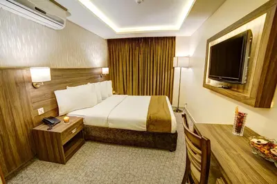 a hotel room with a bed and a television at Nairoukh Hotel Aqaba in Aqaba