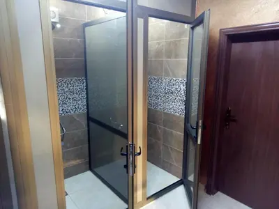 a glass shower with a glass door in a bathroom at Happy Night Hostel in Wadi Musa