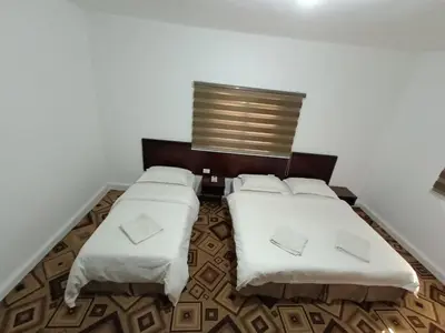 a bedroom with two beds with white sheets at Happy Night Hostel in Wadi Musa