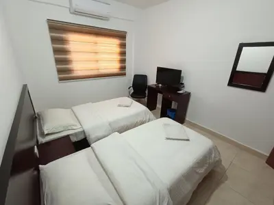 a hotel room with two beds and a television at Happy Night Hostel in Wadi Musa