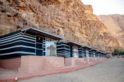 a row of buildings in front of a mountain at Arena Desert Camp & Adventurers in Wadi Rum