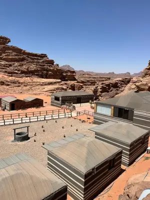 a group of buildings in a desert with rocks at sand magic camp in Wadi Rum