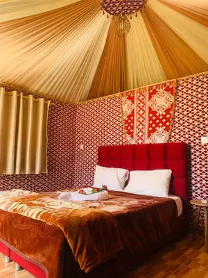 a bedroom with a red bed in a tent at sand magic camp in Wadi Rum