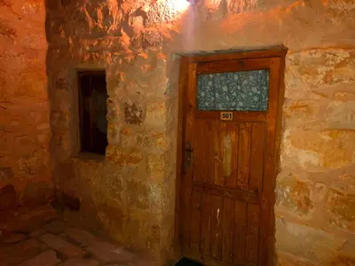 a wooden door in a stone building with a window at The Orient Home in Wadi Musa