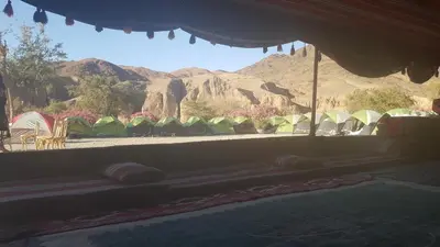 a view of a group of tents with mountains in the background at Wadi Ghwere Camp مخيم وادي الغوير in Al Khuraybah