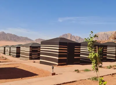 a row of black and white buildings in the desert at Wadi Rum Caravan Camp in Wadi Rum