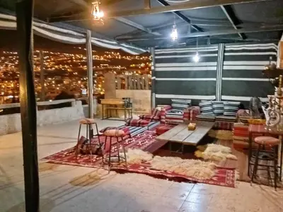 a room with a couch and a table and stools at Infinity Lodge in Wadi Musa