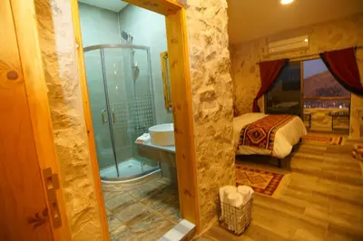 a room with a bathroom with a bed and a shower at Infinity Lodge in Wadi Musa
