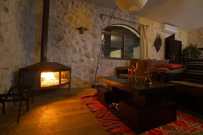 a living room with a fireplace and a couch at Infinity Lodge in Wadi Musa