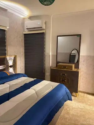 a bedroom with a large bed and a mirror at شركة مسايا لشقق المفروشة in Irbid