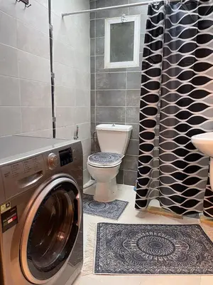 a bathroom with a washing machine and a toilet at شركة مسايا لشقق المفروشة in Irbid