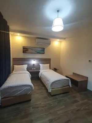 a bedroom with two beds and a light fixture at La Riva Hotel in Aqaba