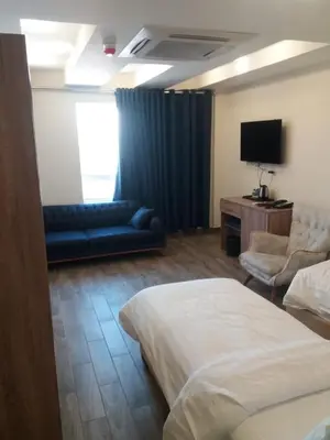 a hotel room with a bed and a couch and a tv at La Riva Hotel in Aqaba