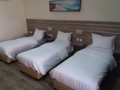 two beds in a room with white sheets at La Riva Hotel in Aqaba