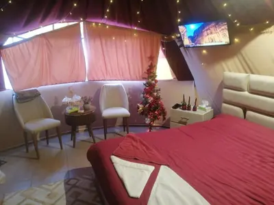 a bedroom with a christmas tree and a bed and chairs at Bubble castle in Kerak