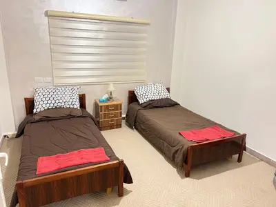 a bedroom with two beds and a night stand at the old house in Kerak