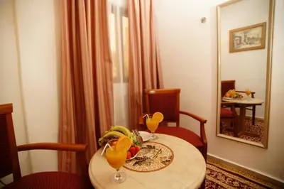 a table with a bowl of fruit and two glasses on it at Petra Plaza Hotel in Wadi Musa