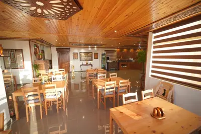 a dining room with wooden tables and chairs at Petra Plaza Hotel in Wadi Musa