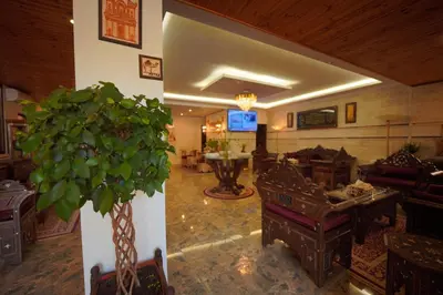 a living room with a plant in the middle of it at Petra Plaza Hotel in Wadi Musa